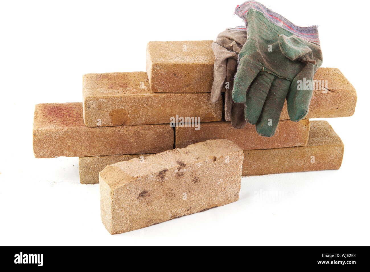 Building a wall with many bricks isolated over white Stock Photo
