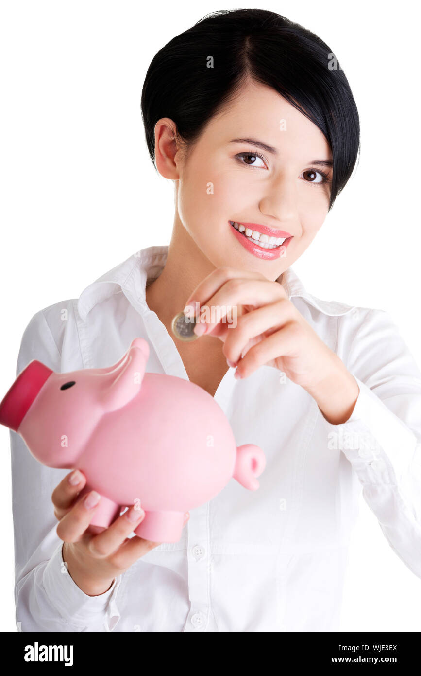 Happy businesswoman putting an euro coin into a piggy bank isolated on ...