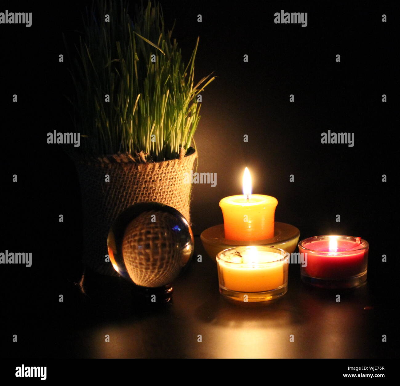 Lit Tea Light Candles By Crystal Ball And Potted Plant On Table Stock Photo  - Alamy
