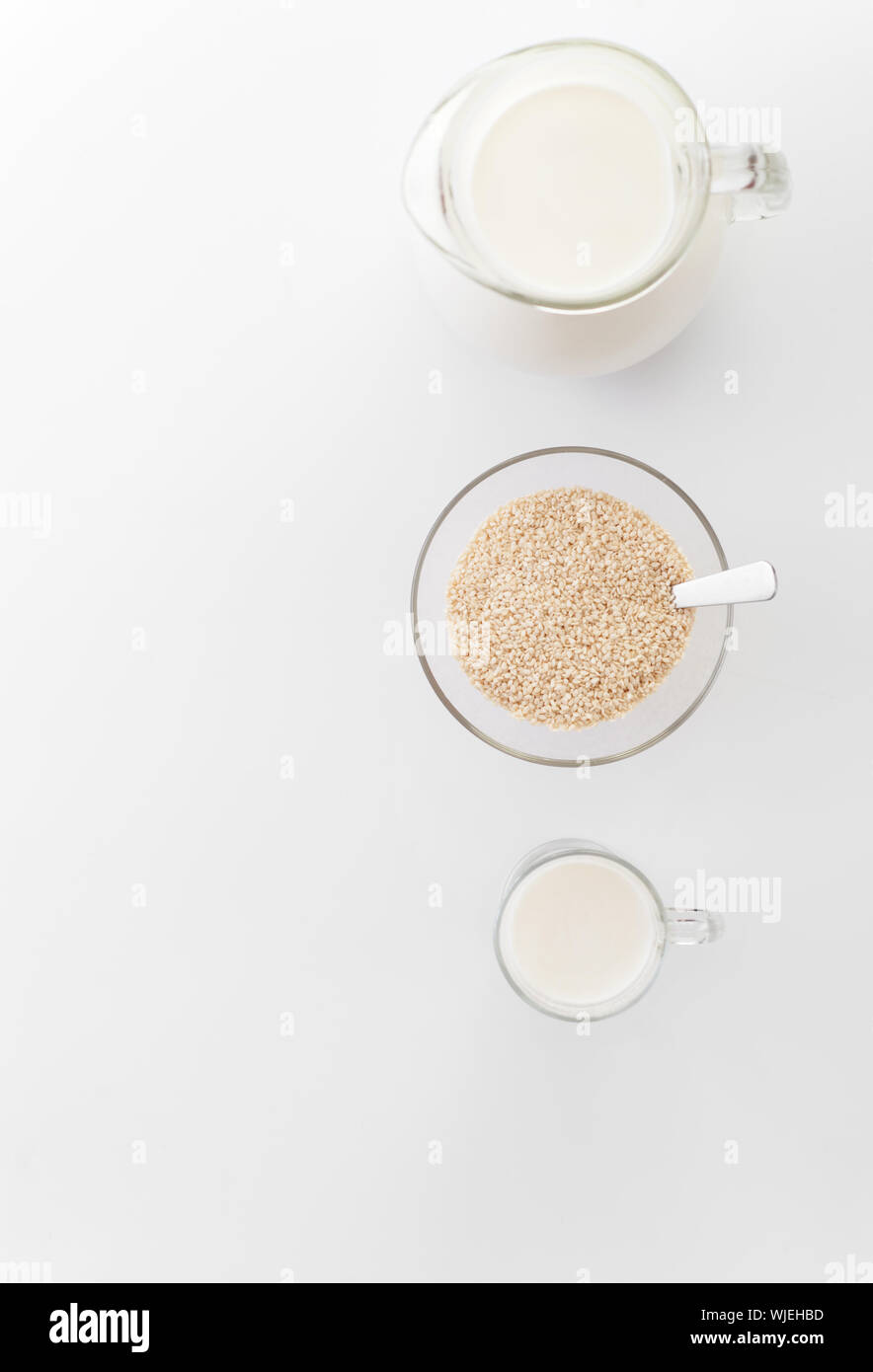 Vegan non diary milk from sesame seeds  in  glass cup  and in the pitcher on light  background. Selective focus. Food and drink, health care, dieting. Stock Photo