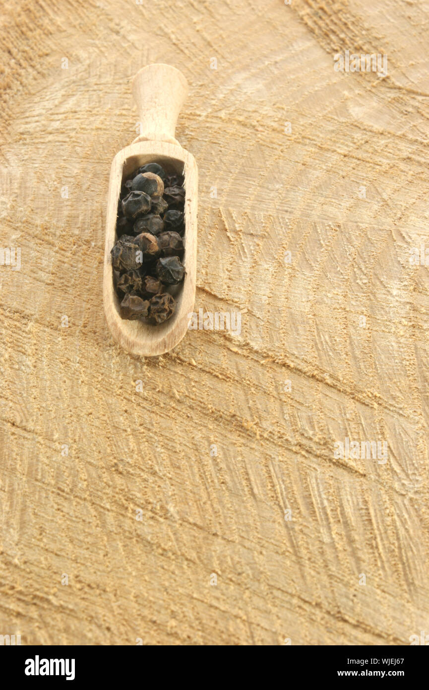 Timber Pepper black pepper in a wooden shovel on a timber board Stock Photo - Alamy