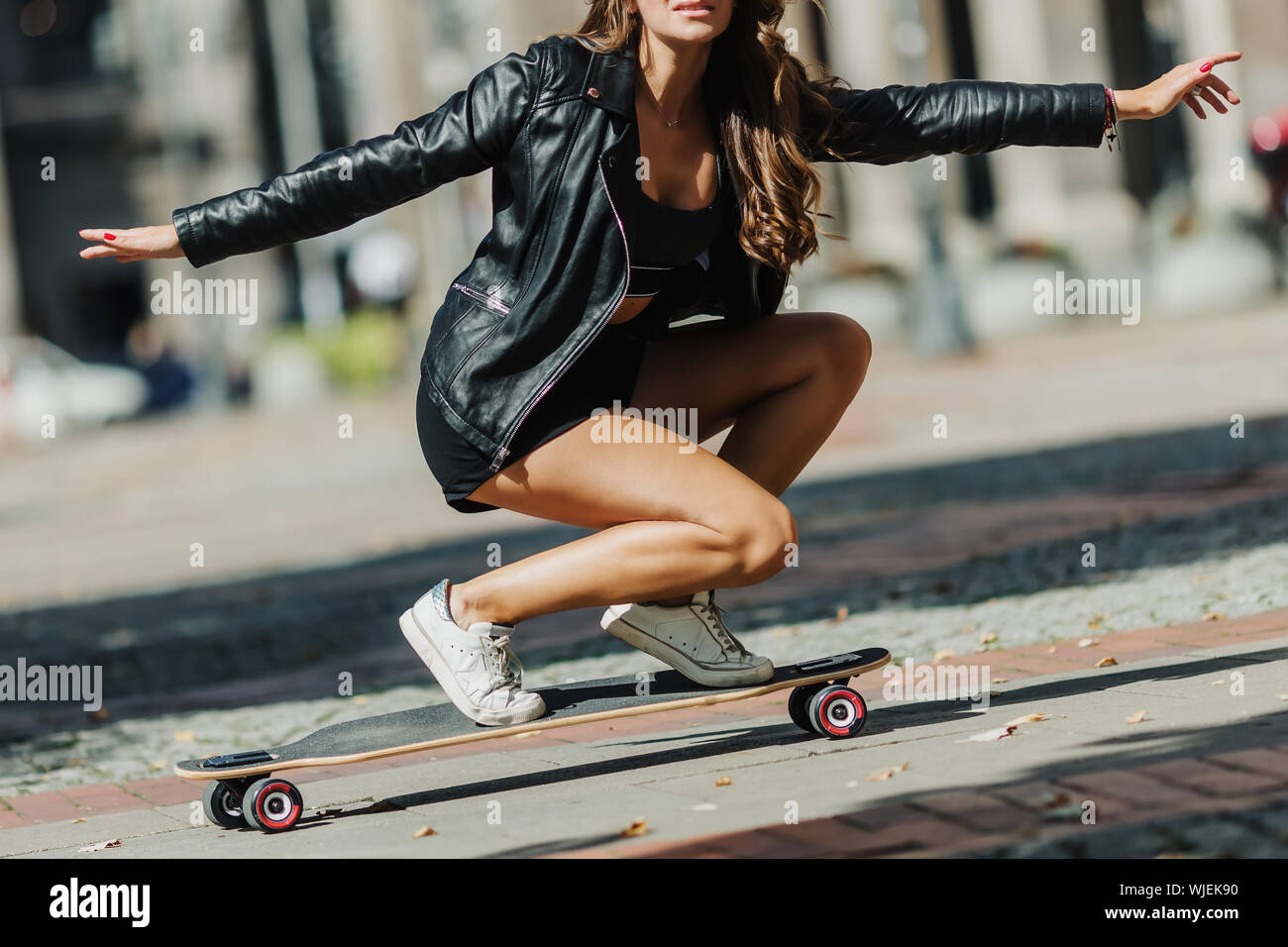 Beautiful young skater woman riding on her longboard in the city. Stylish  girl in street clothes rides on a longboard. Skateboard, street photo, life  Stock Photo - Alamy