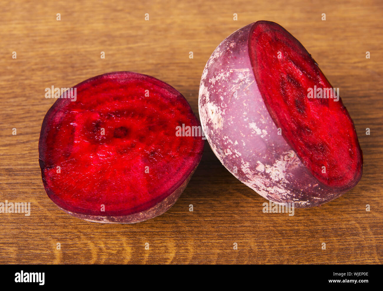 One beetroot divided into two. Over wooden background. Stock Photo