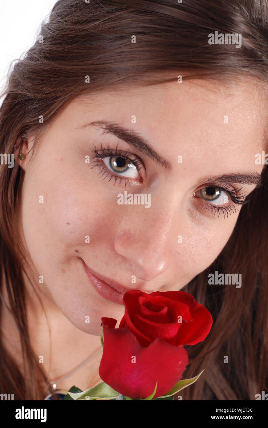 Young woman smelling a red flower Stock Photo