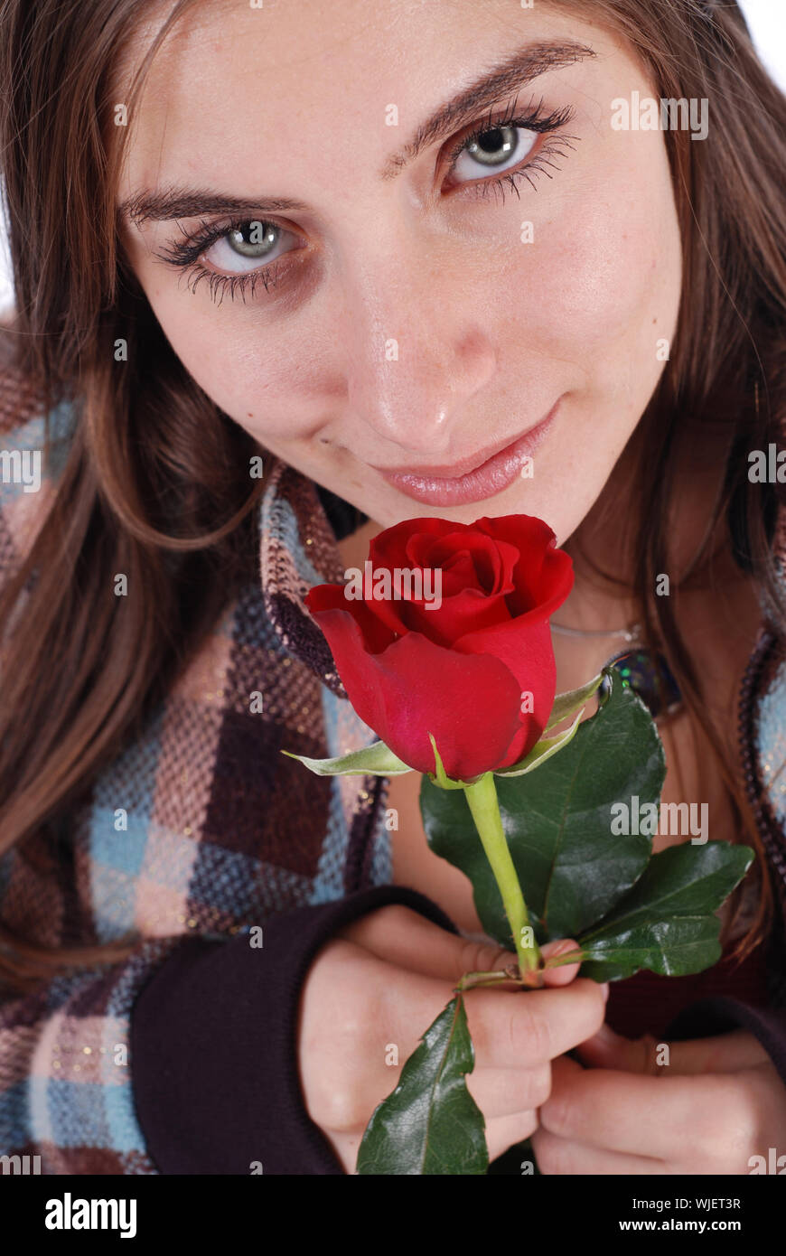 Beautiful woman in plaid coat smelling a rose Stock Photo