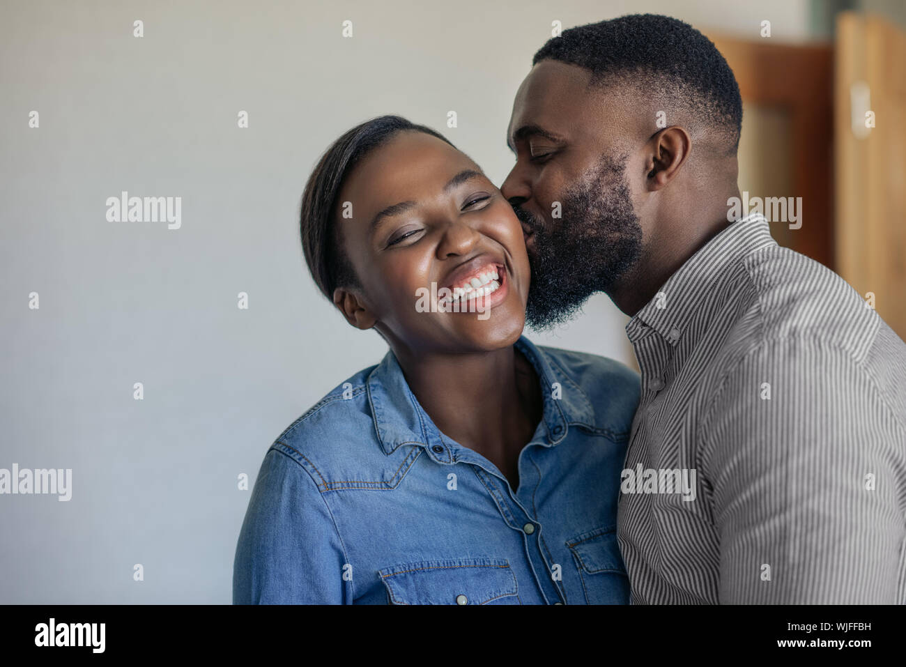 Loving African American wife kissing her husband on the cheek Stock ...