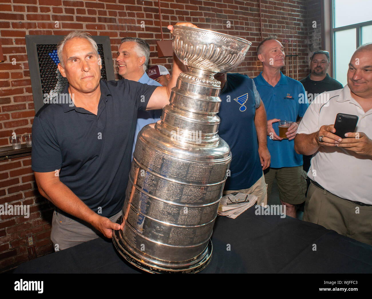 https://c8.alamy.com/comp/WJFFC3/stanley-cup-champion-st-louis-blues-head-coach-craig-berube-places-the-cup-on-a-pool-table-after-he-showed-off-the-nhls-prized-trophy-during-a-visit-WJFFC3.jpg