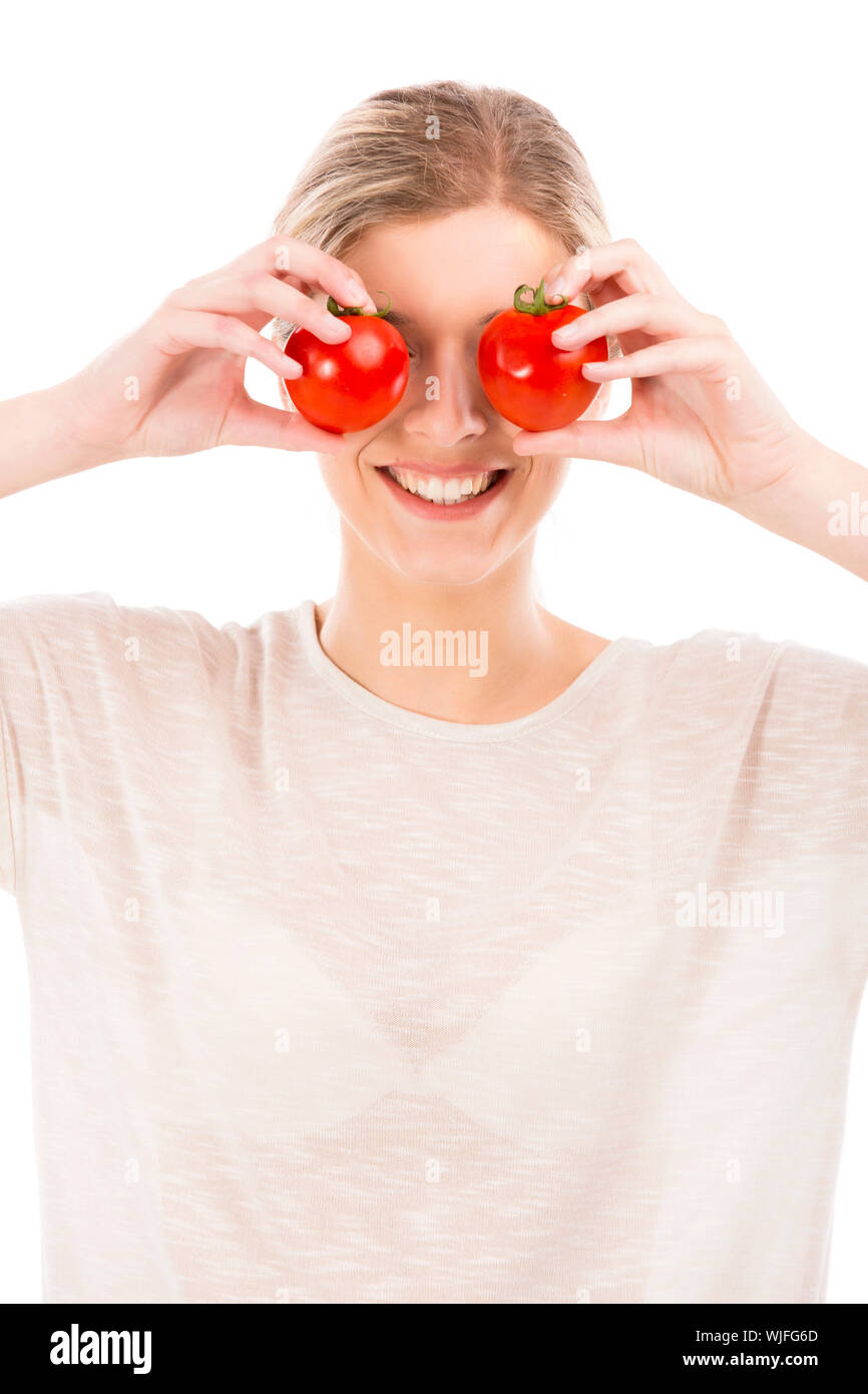 Beautiful girl smiling and holding red tomatoes in front of the eyes ...