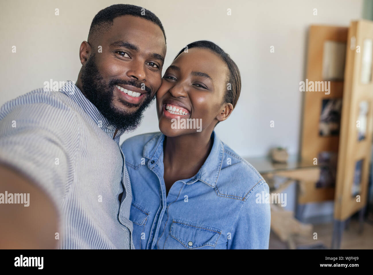 Smiling young African American couple taking a selfie at home Stock Photo