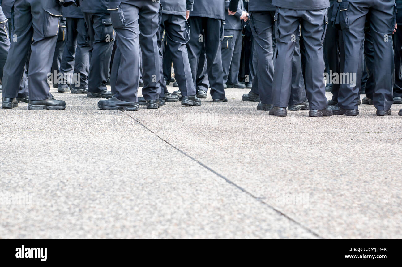 Low Section Of Police Force Standing On Road Stock Photo