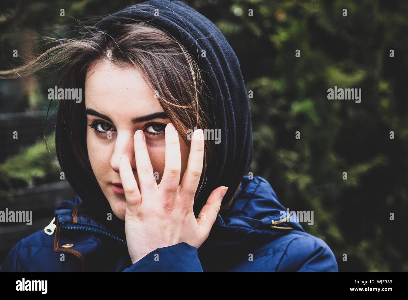 Close-up Portrait Of Beautiful Young Woman With Hand On Face Stock Photo