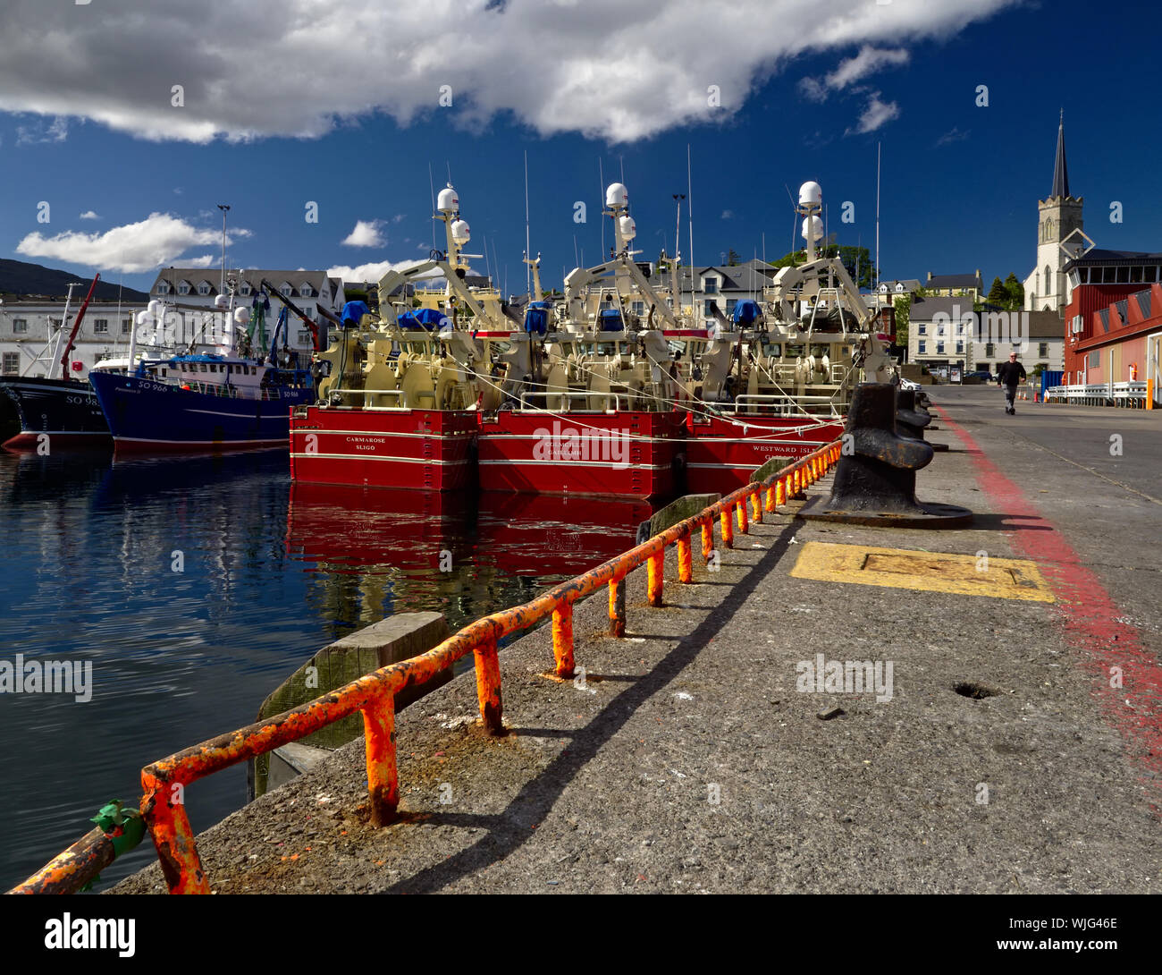 Killybegs, Co. Donegal, Ireland - May 21st, 2019 - Three identical red fishing vessels moored side by side at the pier in Killybegs Harbour (rear view Stock Photo
