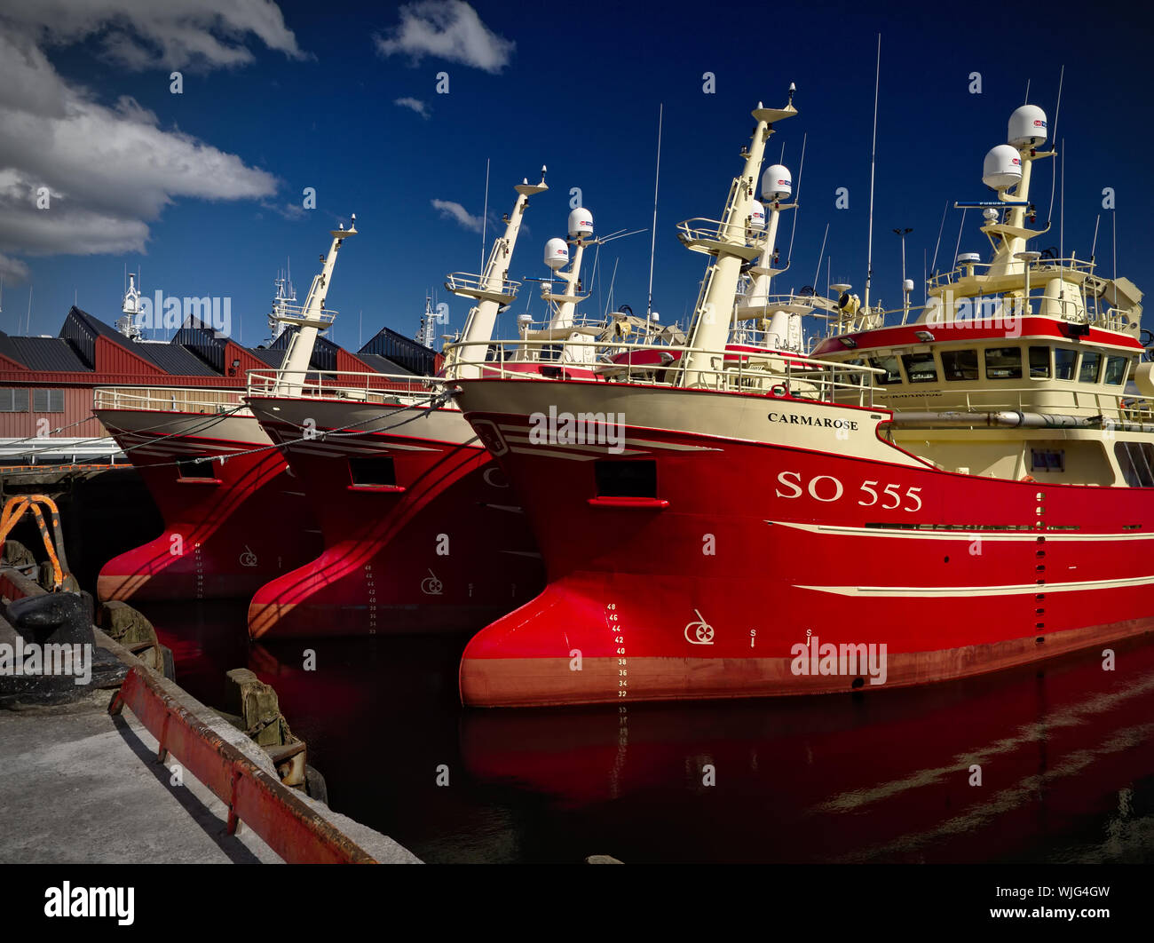 Killybegs, Co. Donegal, Ireland - May 21st, 2019 - Three identical red fishing vessels moored side by side at the pier in Killybegs Harbour Stock Photo