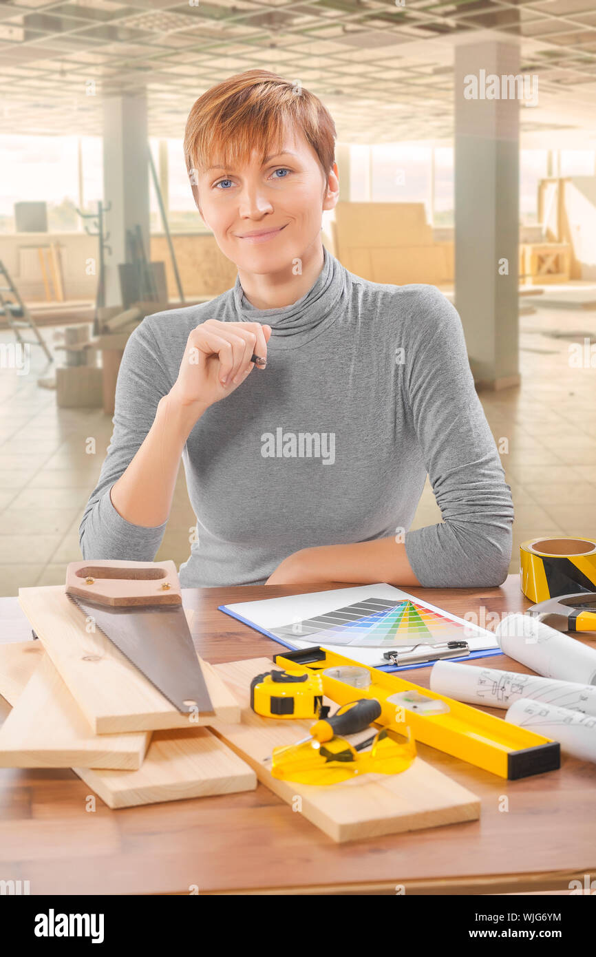 female worker sitting at table with tools Stock Photo