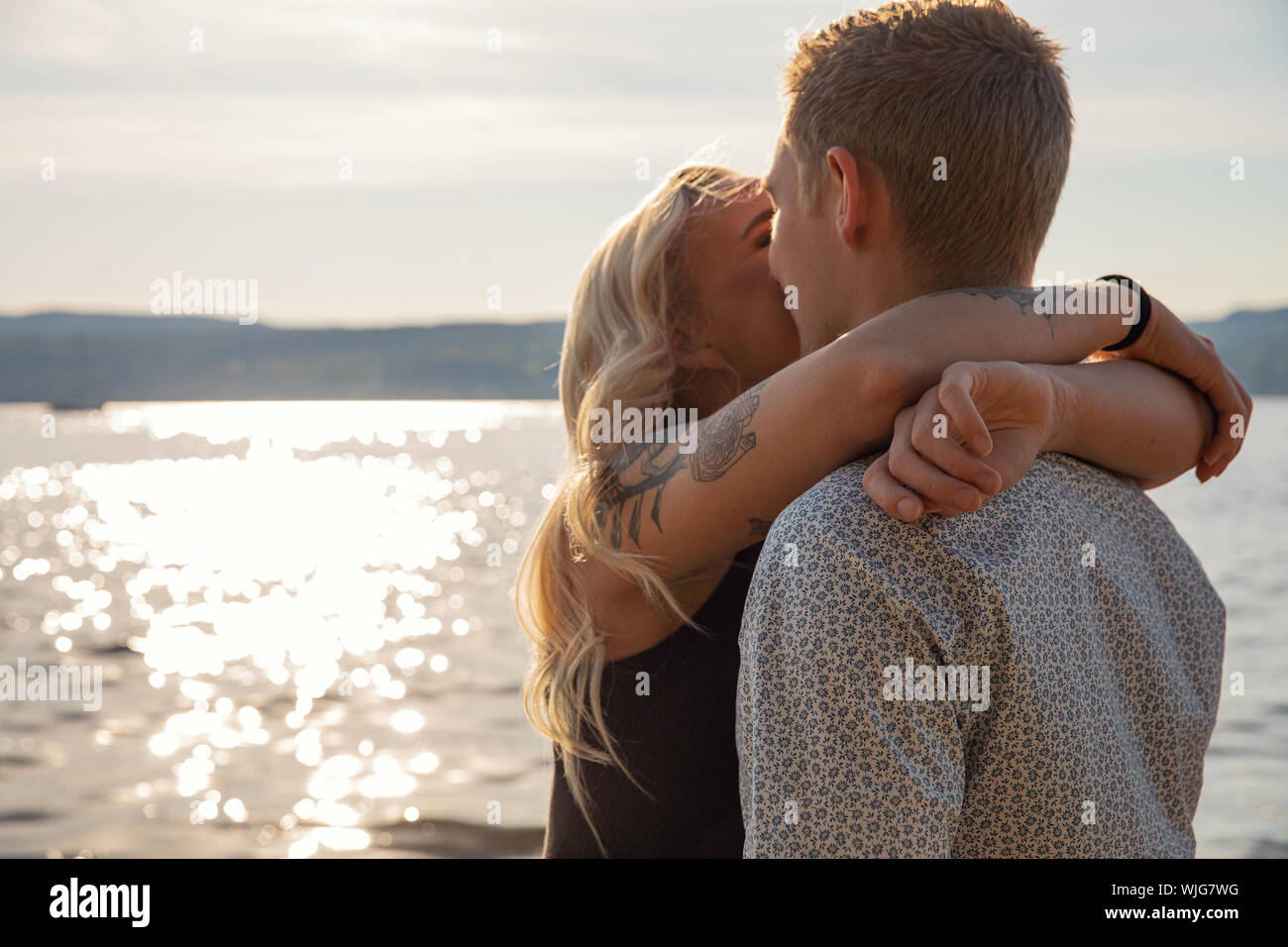 Kissing couple in romantic embrace on beach at summer Stock Photo