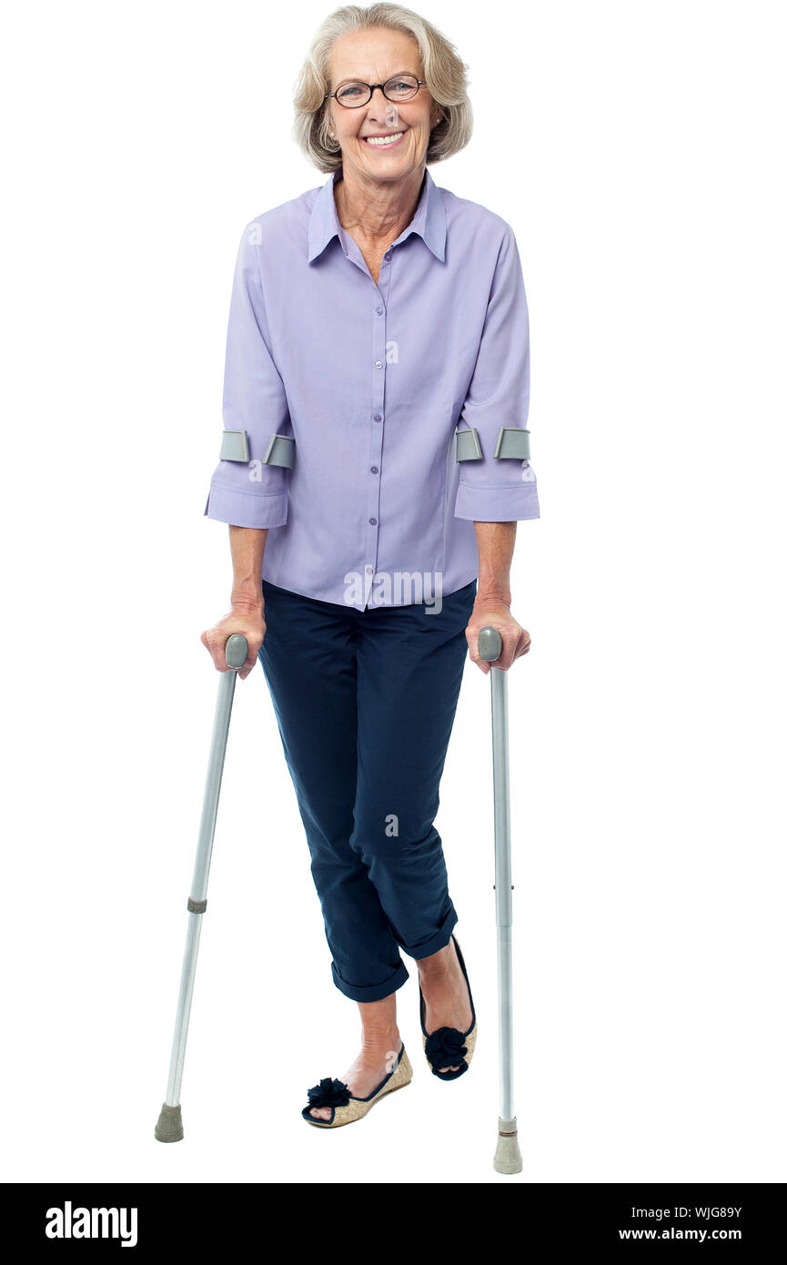 Senior woman walking with the help of crutches Stock Photo - Alamy