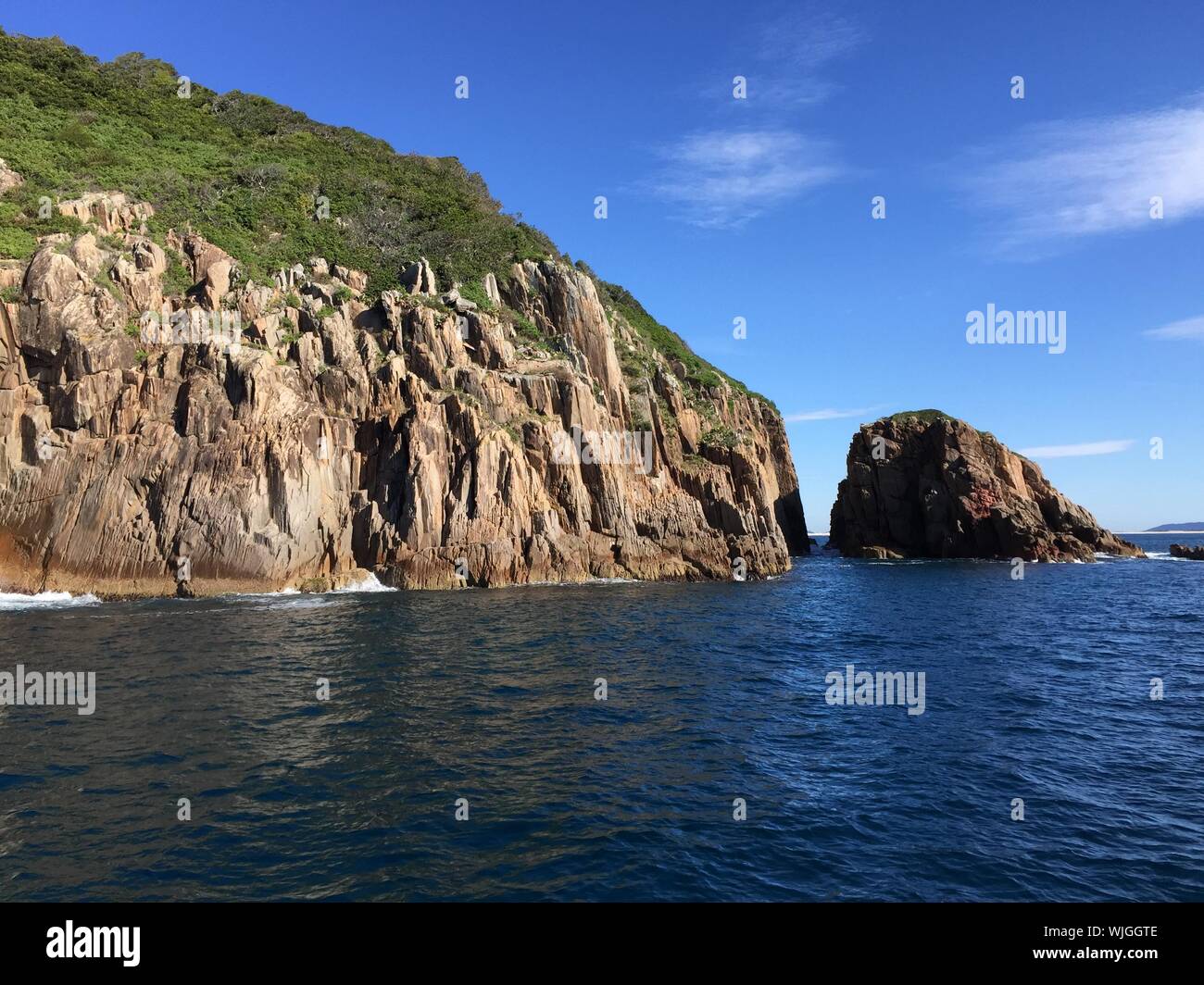 Idyllic Shot Of Rocky Cliffs In Sea Against Nelson Bay Stock Photo