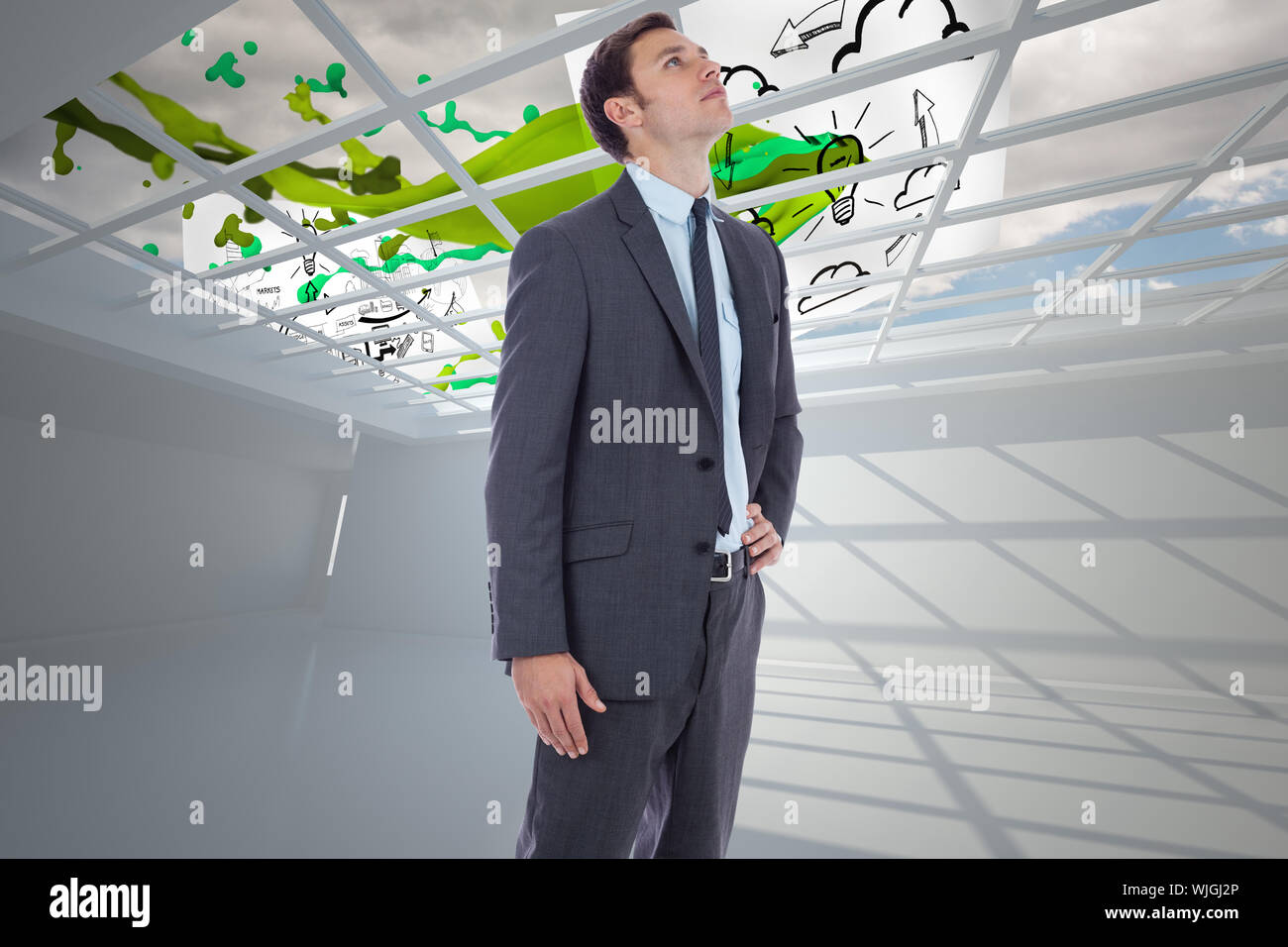 Serious businessman with hand on hip against business papers flying ...