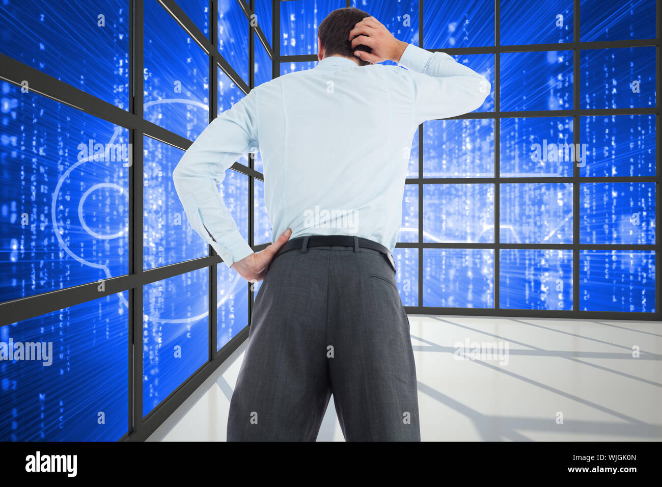 Thinking businessman with hand on head against glowing key seen through ...