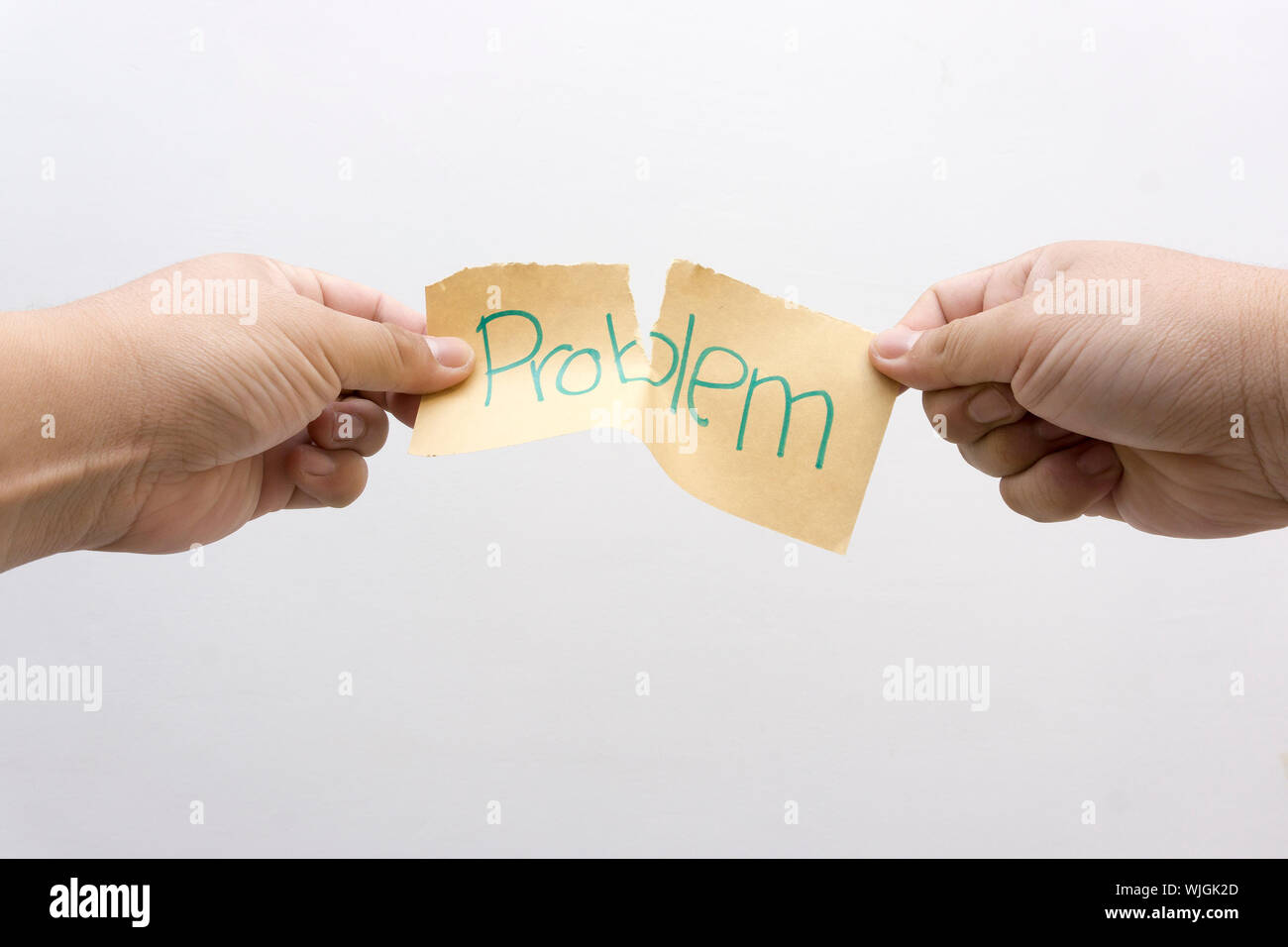 Cropped Hands Of Man Tearing Paper With Problem Text Stock Photo