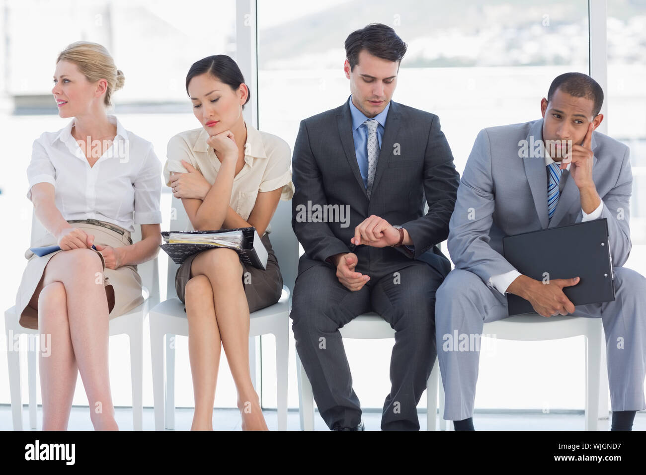 Four business people waiting for job interview in a bright office Stock
