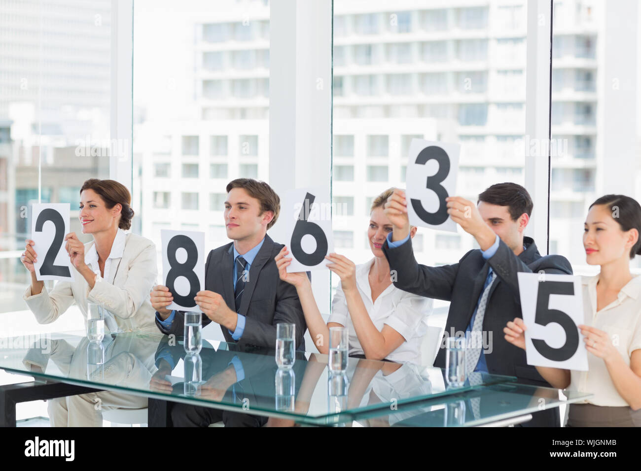 Group of panel judges in a row holding score signs Stock Photo Alamy