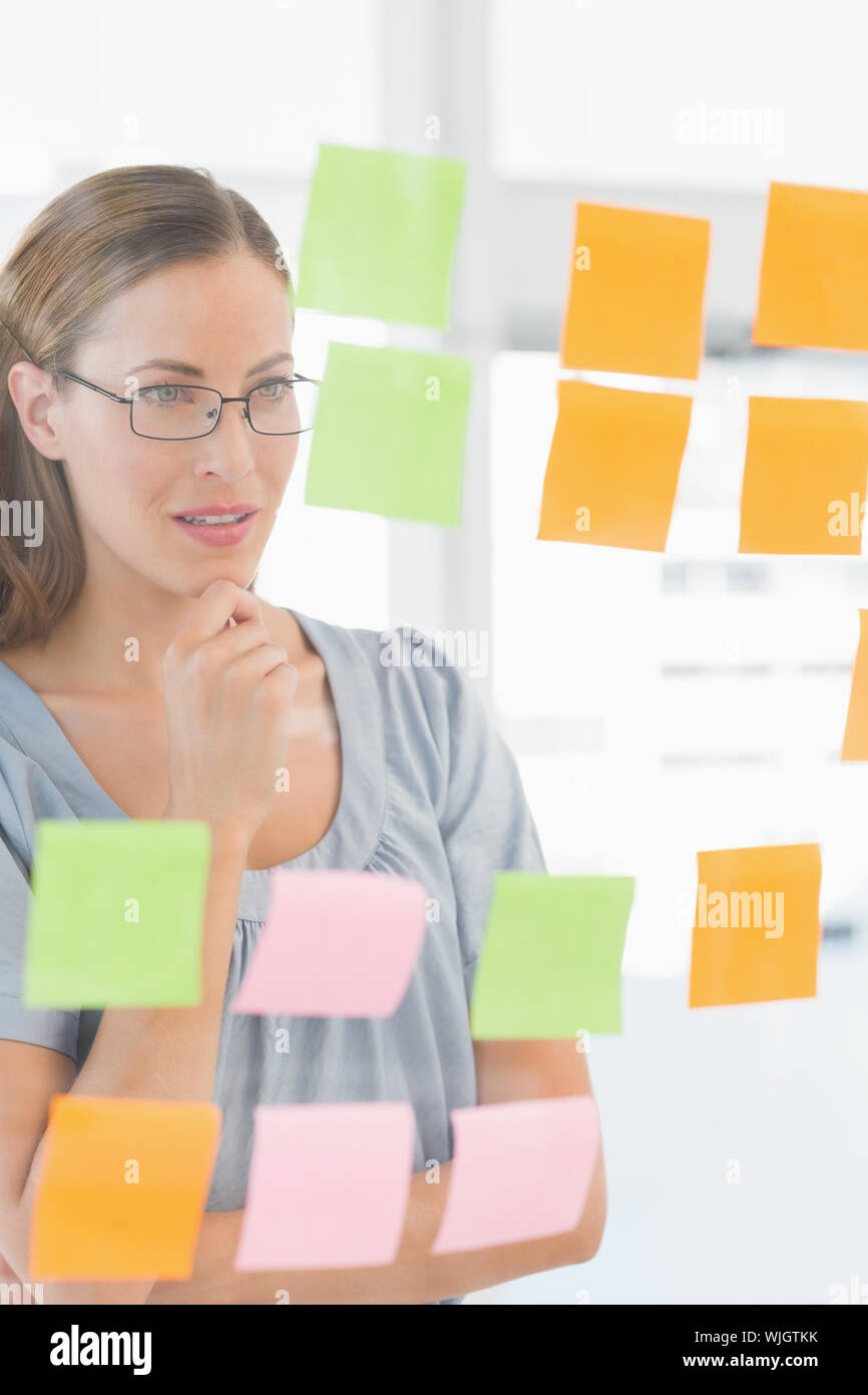 Concentrated female artist looking at colorful sticky notes at the ...