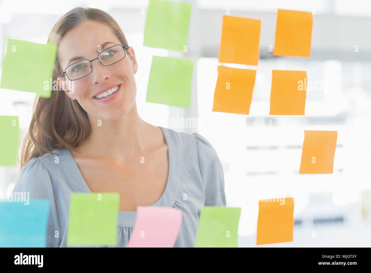 Concentrated female artist looking at colorful sticky notes at the ...