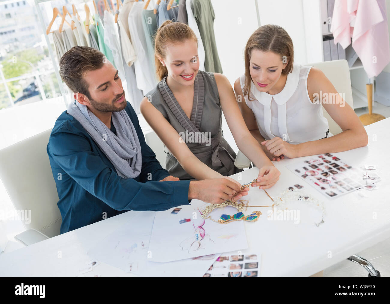 Three fashion designers discussing designs in a studio Stock Photo Alamy