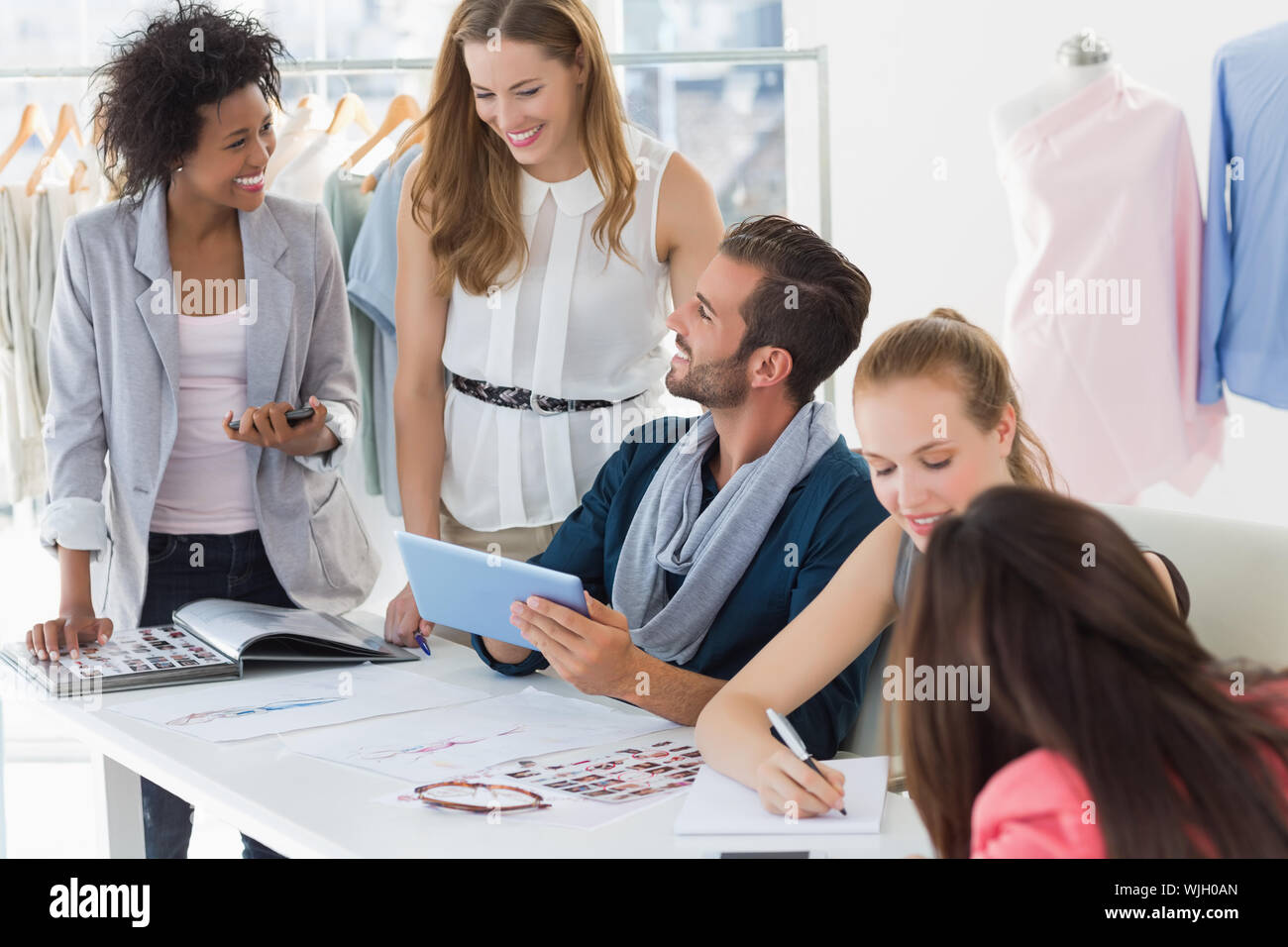 Group of fashion designers discussing designs in a studio Stock Photo ...