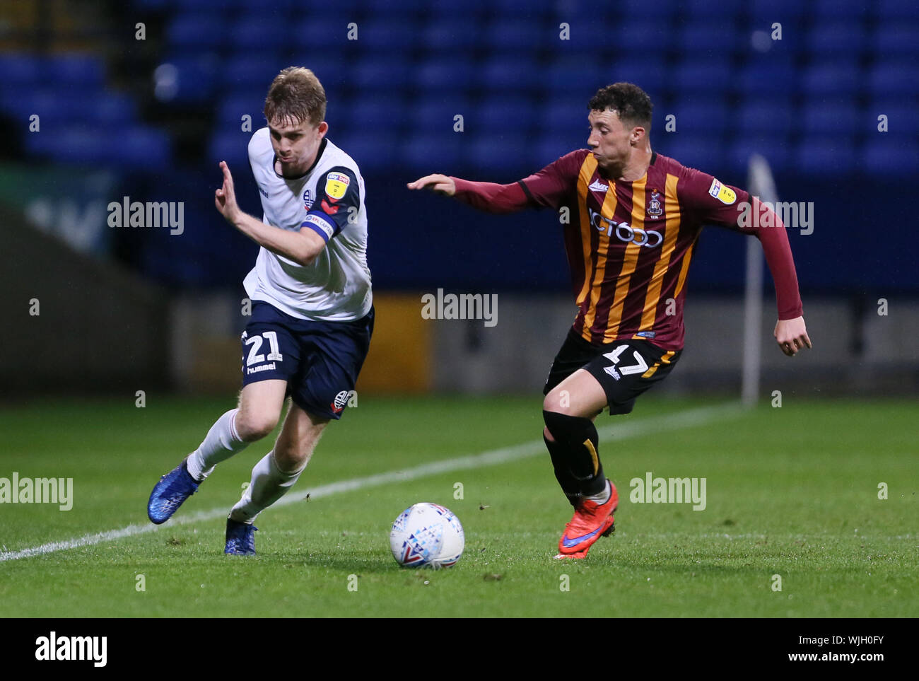 Bolton Wanderers' Harry Brockbank and Bradford City's Jordan Gibson (right)  battle for the ball during the EFL Trophy Northern Section Group F match at  the University of Bolton Stadium Stock Photo -