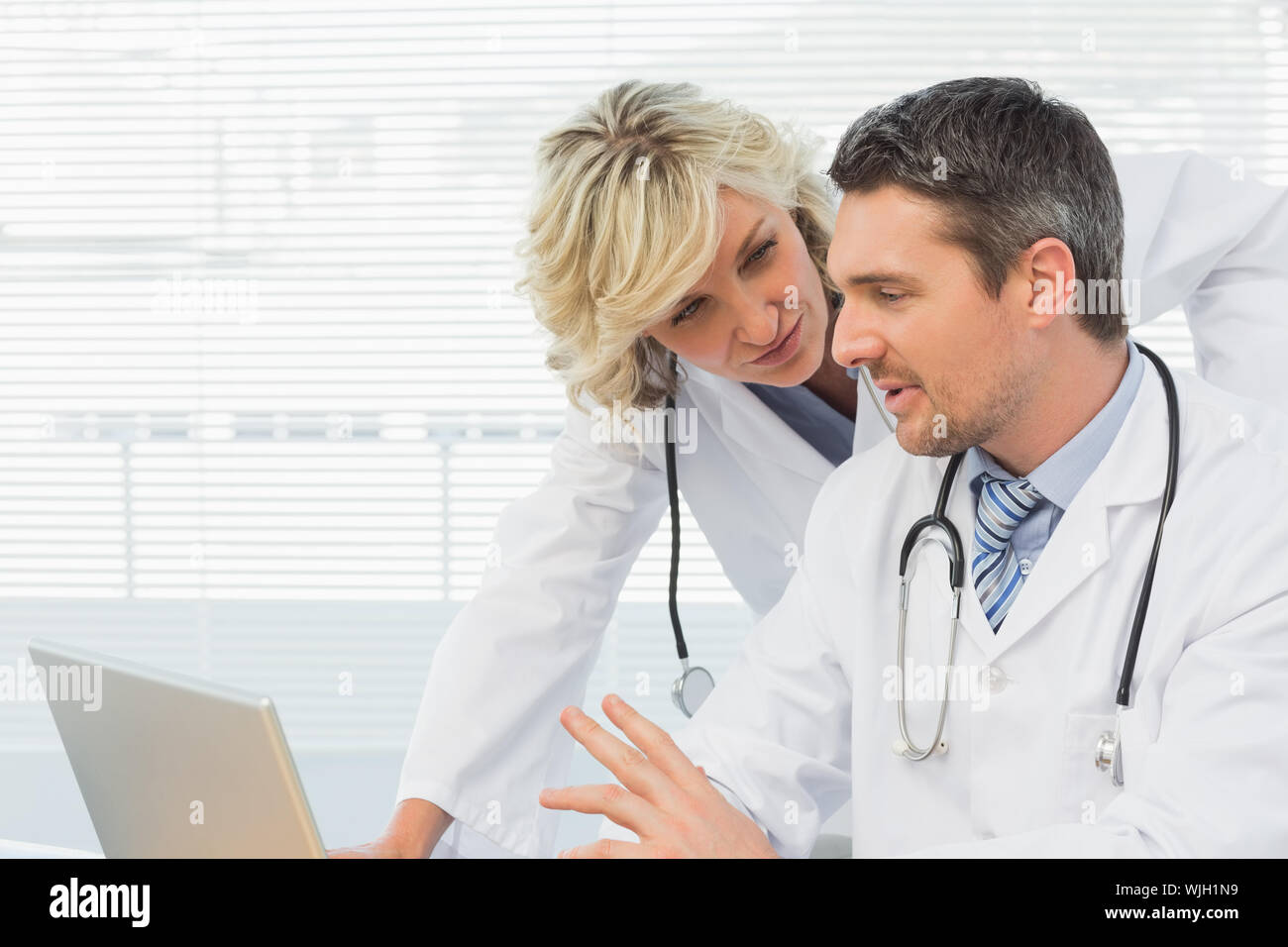 Two concentrated doctors using laptop together at the medical office Stock Photo