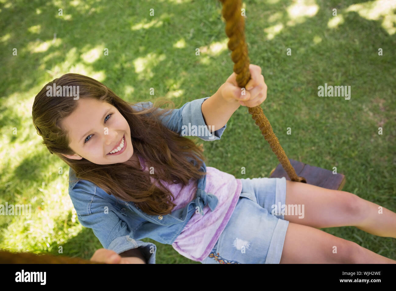 High angle view of a cute little young girl sitting on swing Stock ...