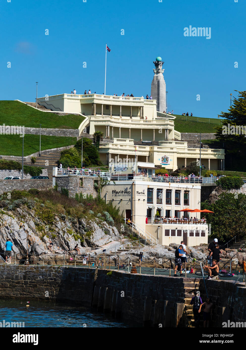 Anglers on West Hoe pier, Plymouth, Devon, UK, against a backdrop of Plymouth Hoe and the terraced Belvedere Wedding Cake building Stock Photo