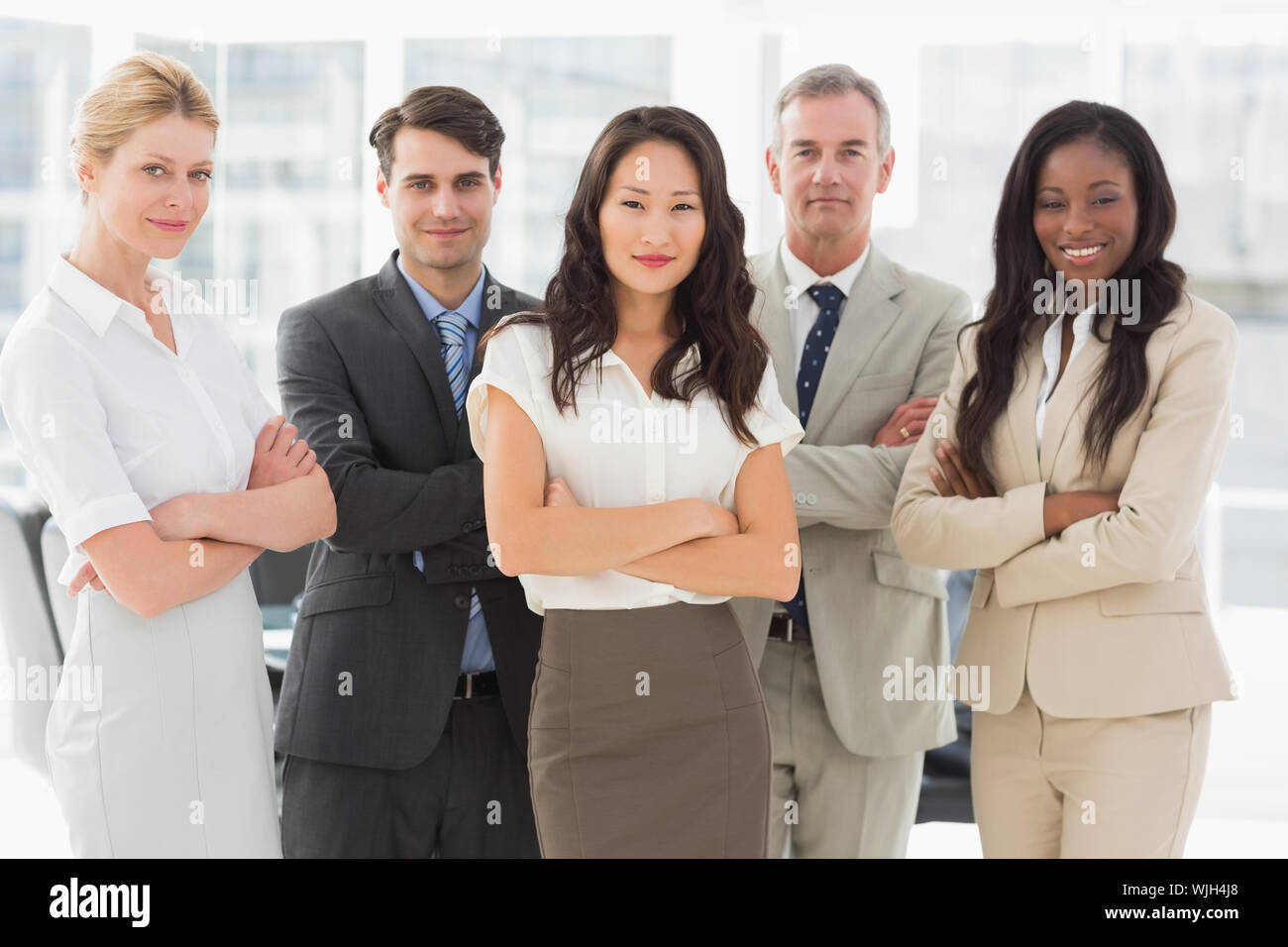 Business team smiling at camera with arms crossed in the office Stock ...