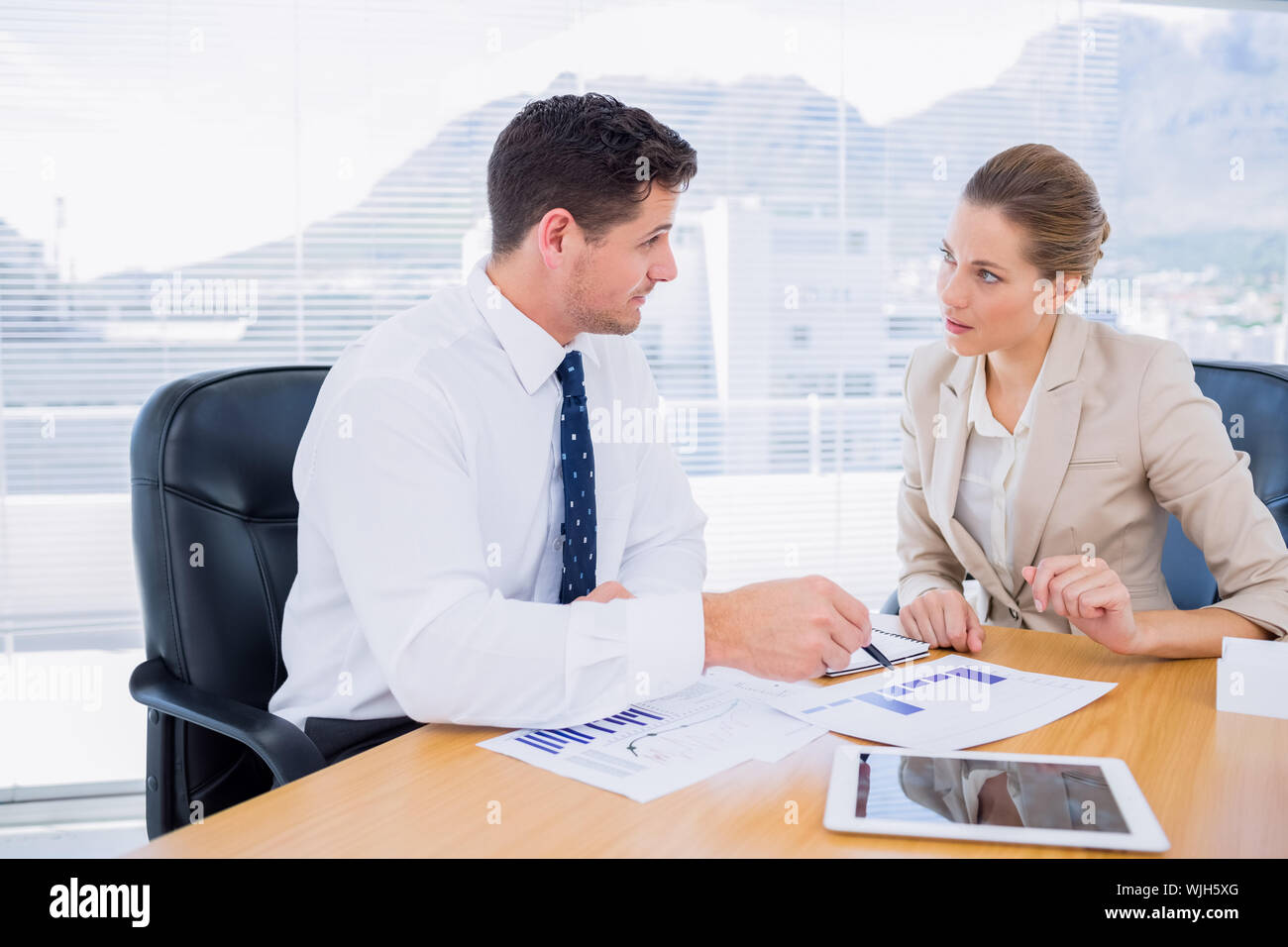 Smartly dressed young man and woman in a business meeting at office ...