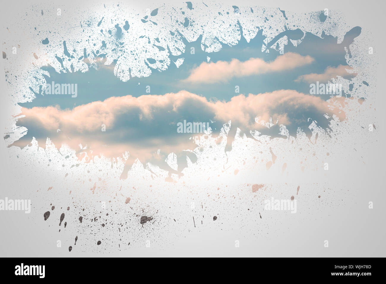 Splash on wall revealing blue sky Stock Photo