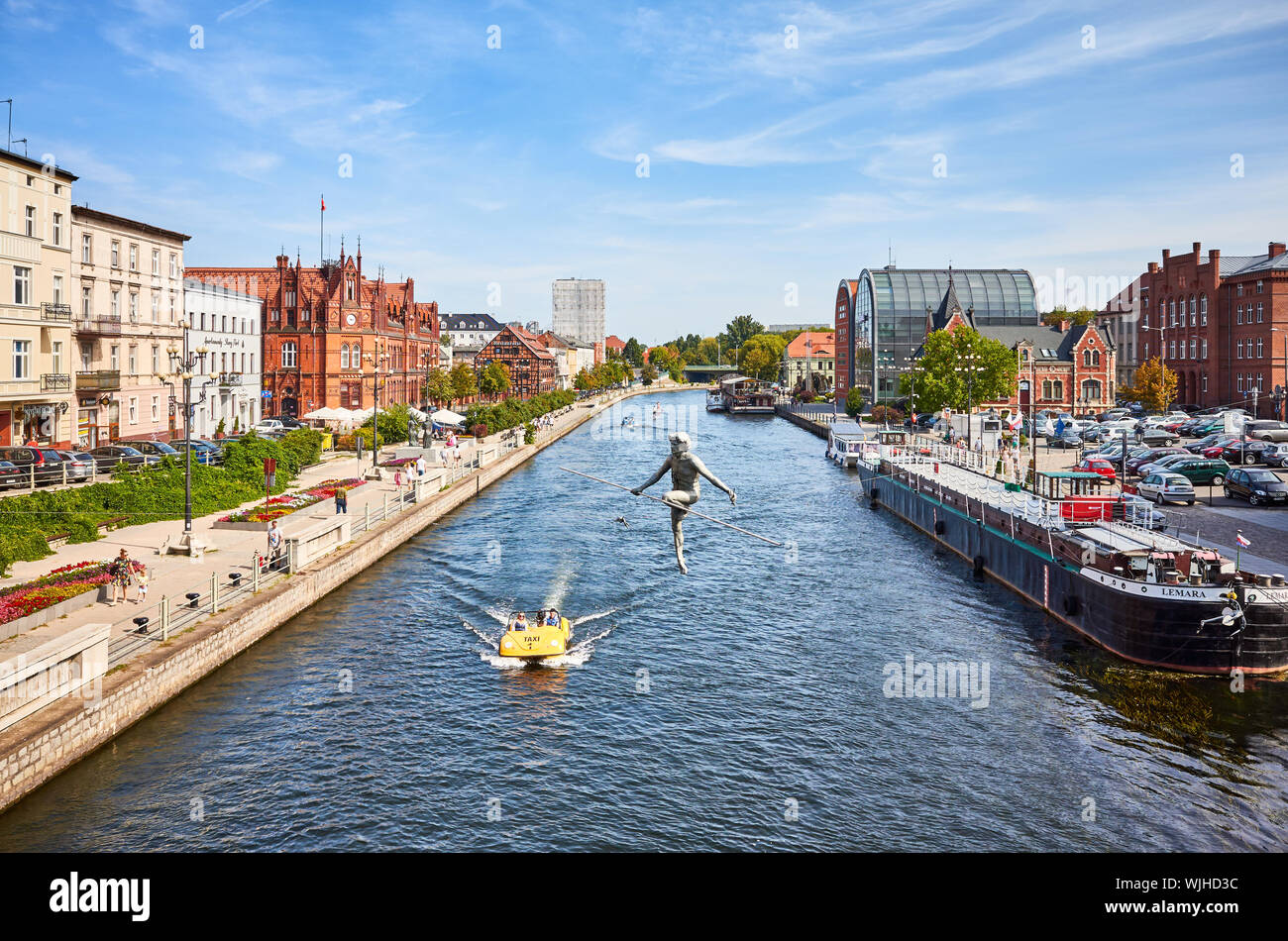Bydgoszcz, Poland - August 25, 2019: Bydgoszcz cityscape seen from a bridge with tightrope walker sculpture over Brda River. Stock Photo