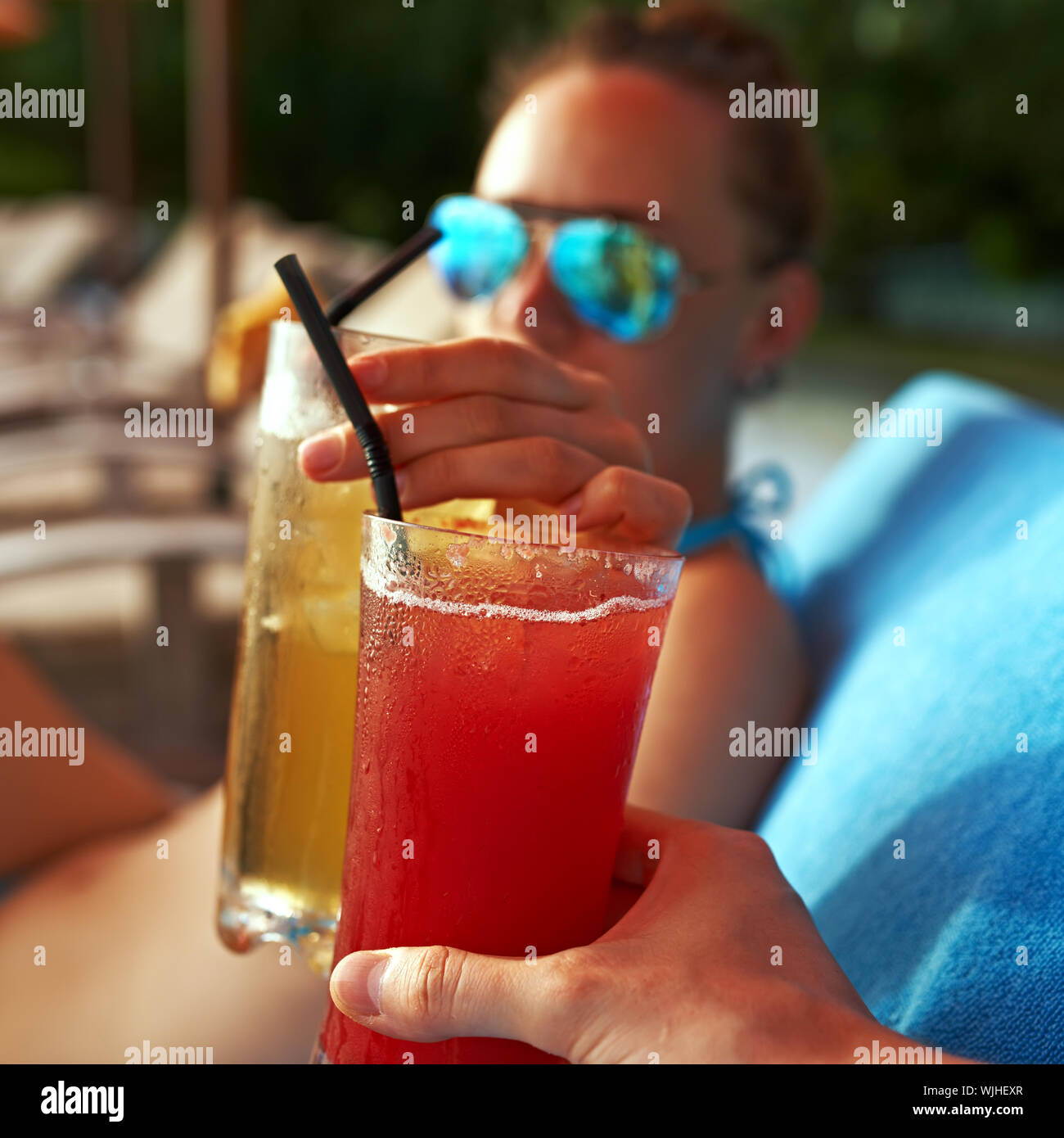 Couple clinking glasses with cocktails at poolside Stock Photo Alamy