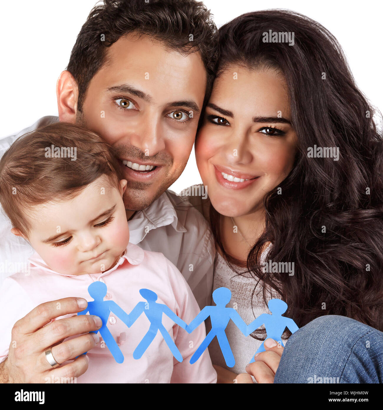 Beautiful family together isolated on gray background, happy young parents carry little daughter, people-shaped blue paper bonding toy in hands, toget Stock Photo
