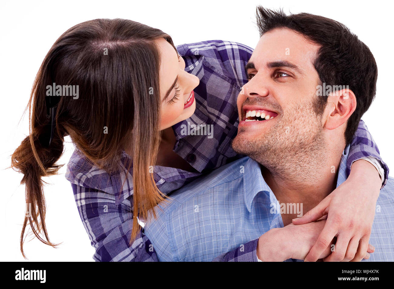 Closeup portrait of a cute young woman hugging her husband from behind ...