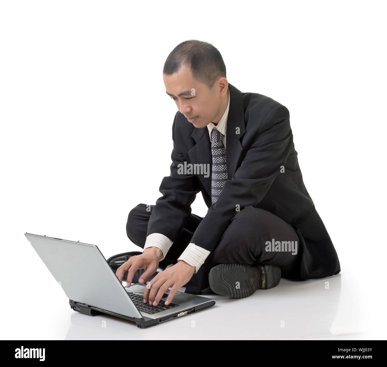 Asian businessman using laptop on ground, full length portrait on white ...