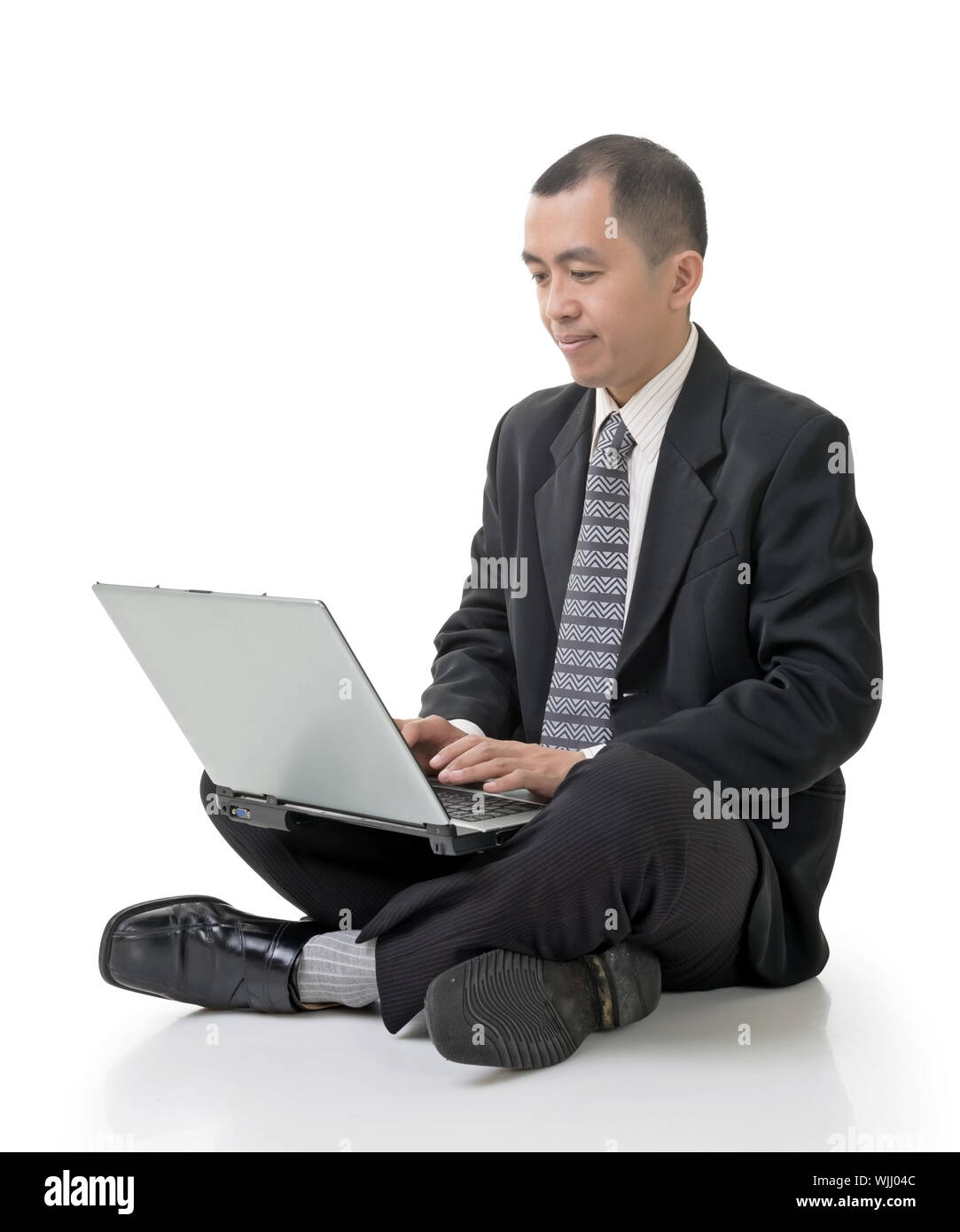 Asian businessman using laptop on ground, full length portrait on white ...