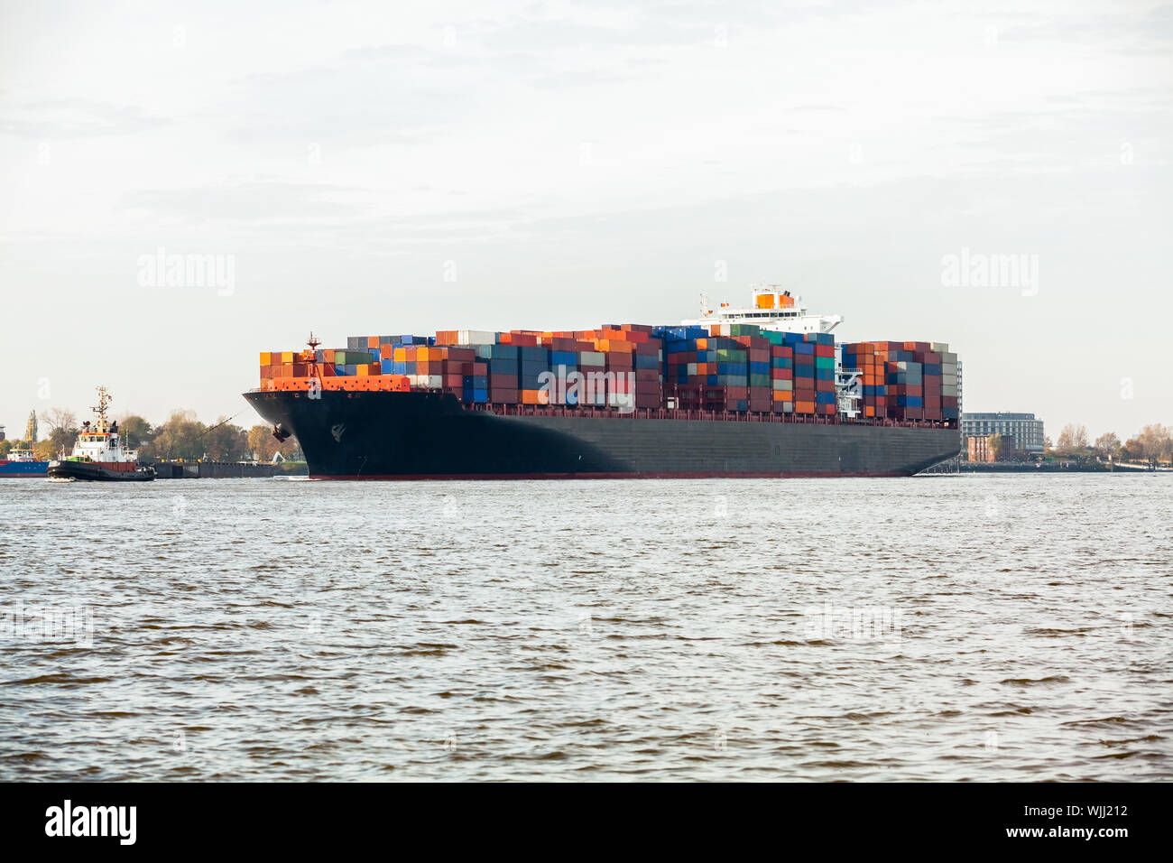 Fully laden container ship in port with its decks stacked with metal containers full of freight