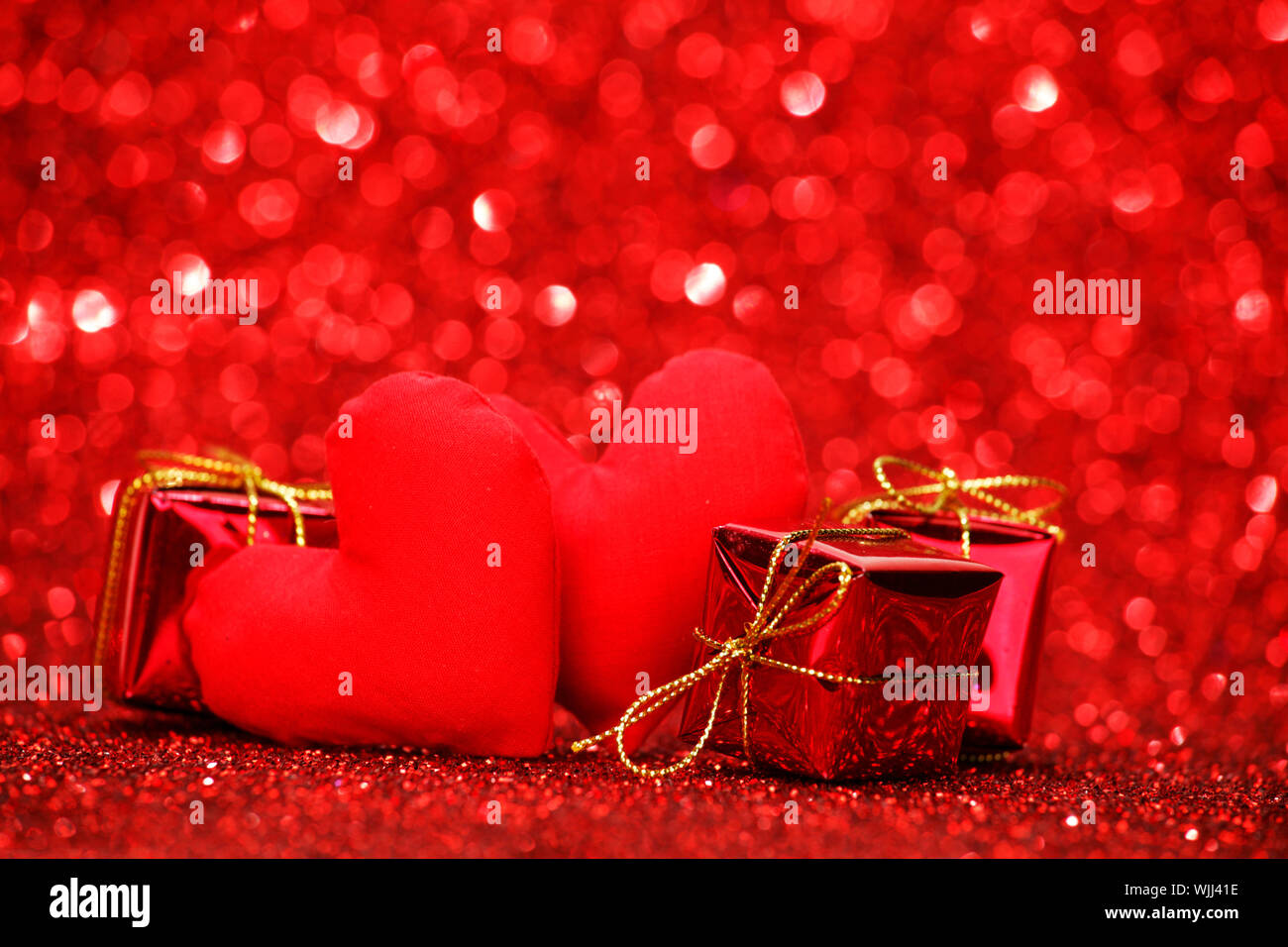 Valentines day gifts and hearts on red glitter background Stock Photo ...