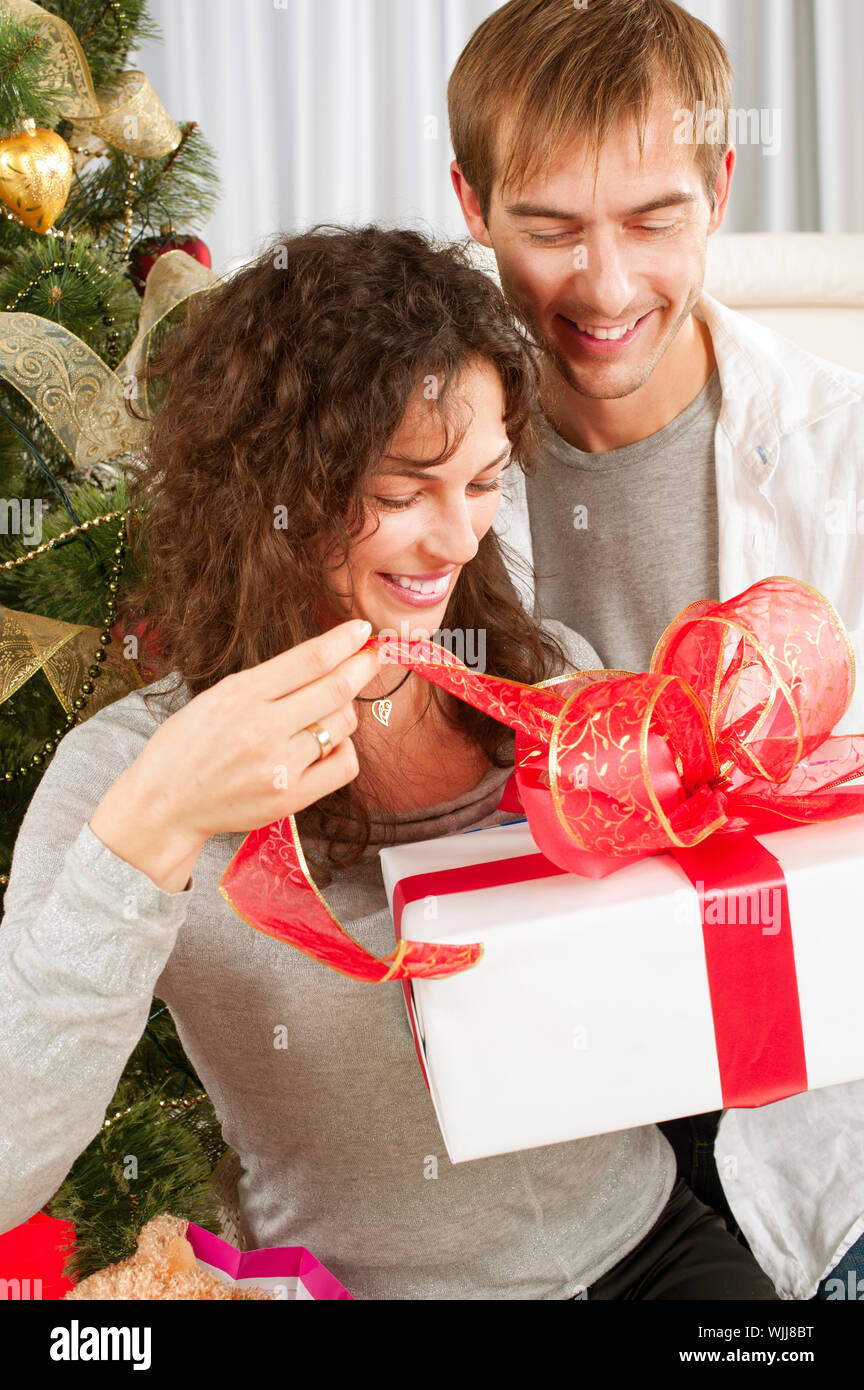 Christmas Gift. Happy Couple with Christmas and New Year Gift at Home