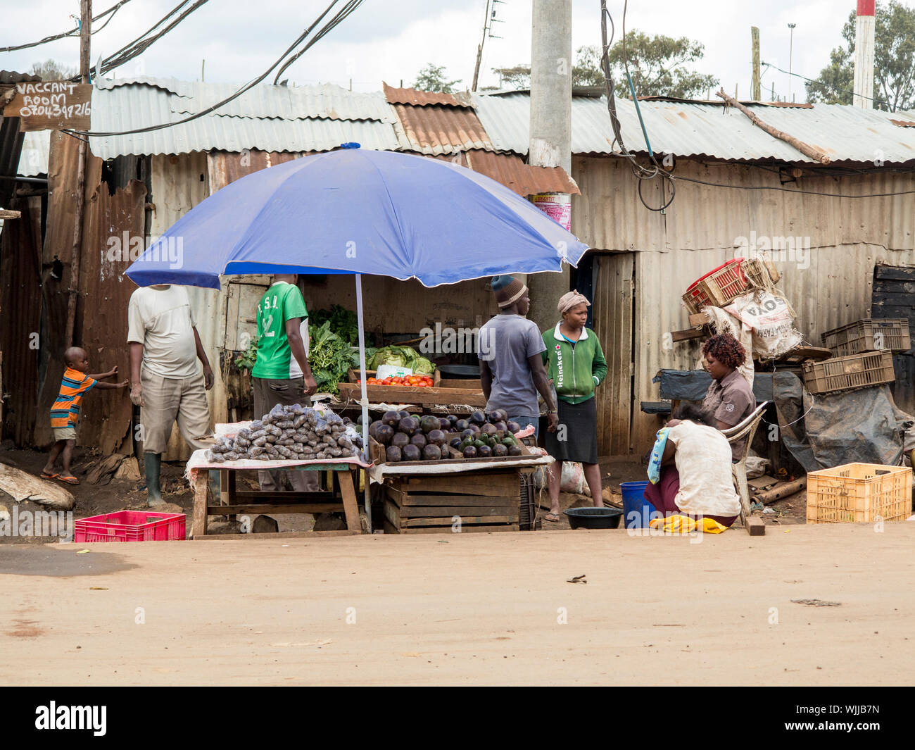 KIBERA, KENYA-NOVEMBER 6, 2015: Unidentified people work at a vegetable stand in Kibera, the largest urban slum in Africa. Stock Photo