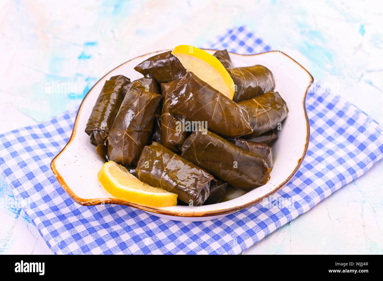 Traditional greek cuisine. Wrapped rice in grape leaves. Dolma with lemon and spices. Home