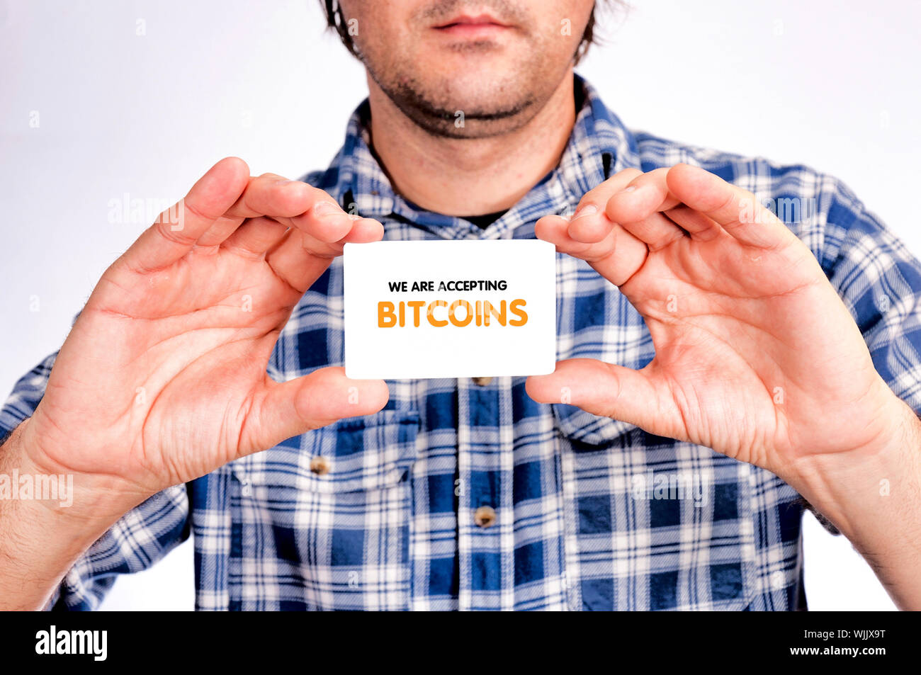 Man holding card with bitcoins accepting sign Stock Photo - Alamy