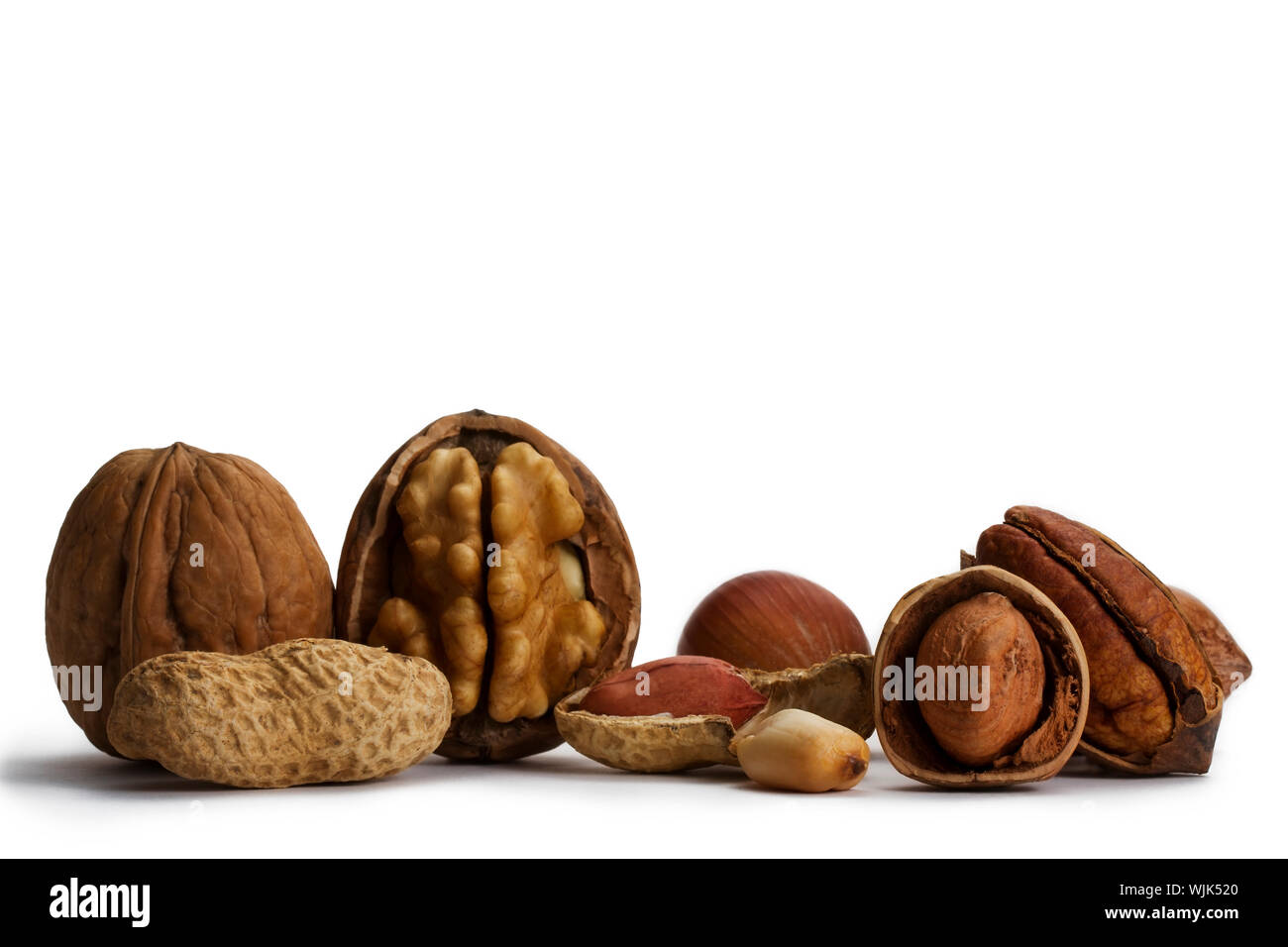cracked and closed pecans walnuts hazelnuts and peanuts on white